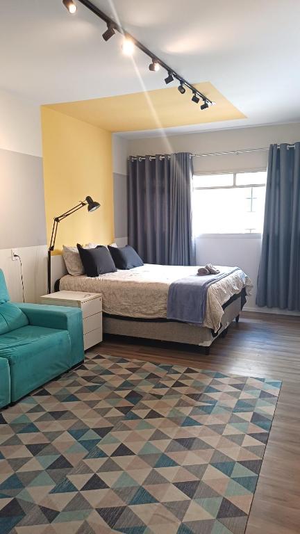 a bedroom with a large bed and a couch at Barreto Leme Studio 12 in Campinas