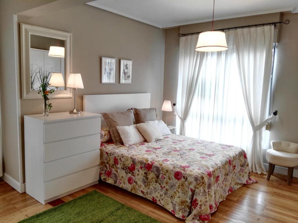 a bedroom with a bed and a dresser and a window at Apartamento Getxo Tranquility by I Love Norte in Getxo
