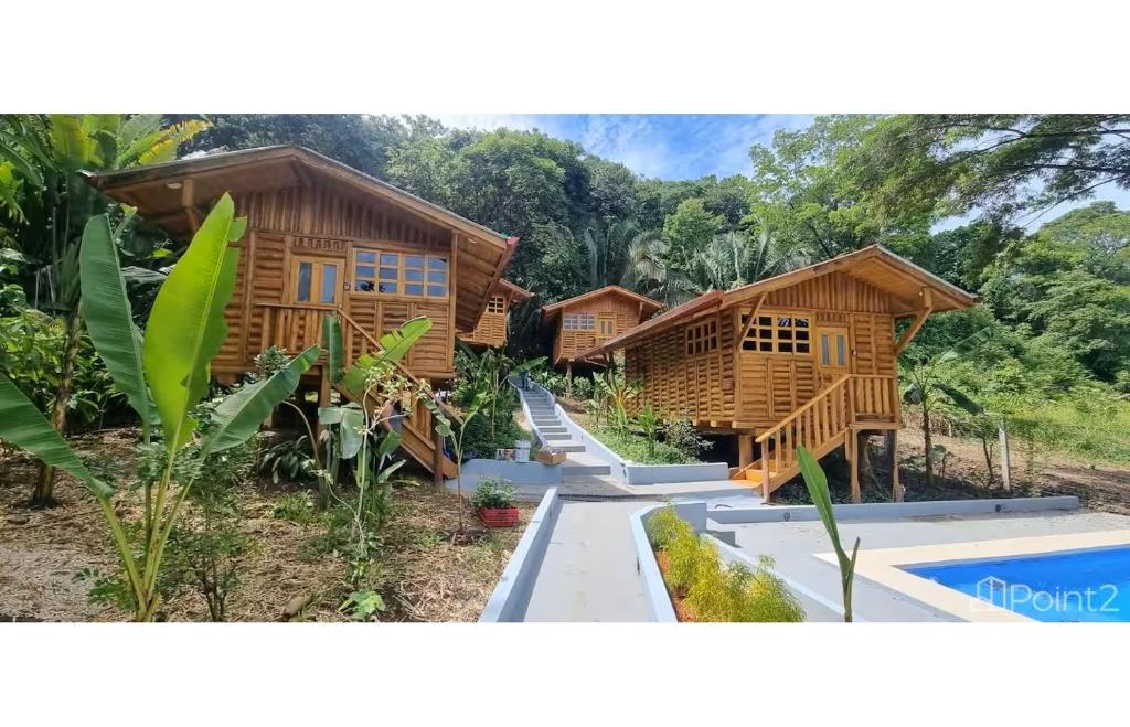 a wooden house with a pool in front of it at Cabañas Samara Buenavista in Sámara