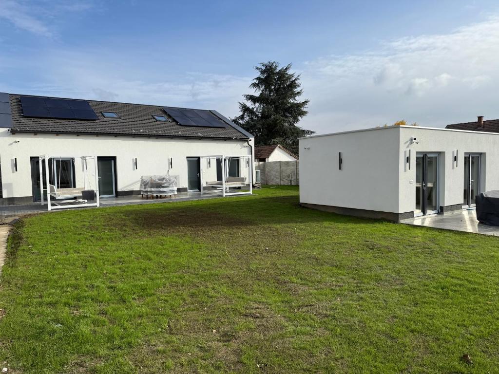a white house with solar panels on it at WBR Apartlak in Villány