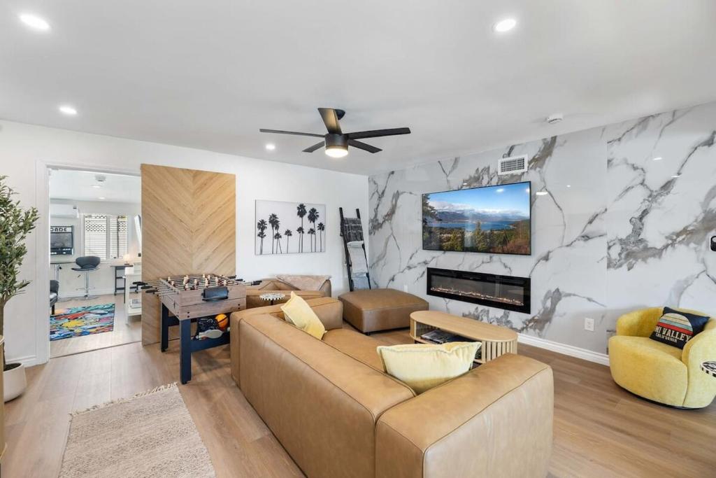 a living room with a couch and a tv on a wall at 2BR 2BA Home Hot Tub, Firepit, Yard, BBQ, Parking in Simi Valley