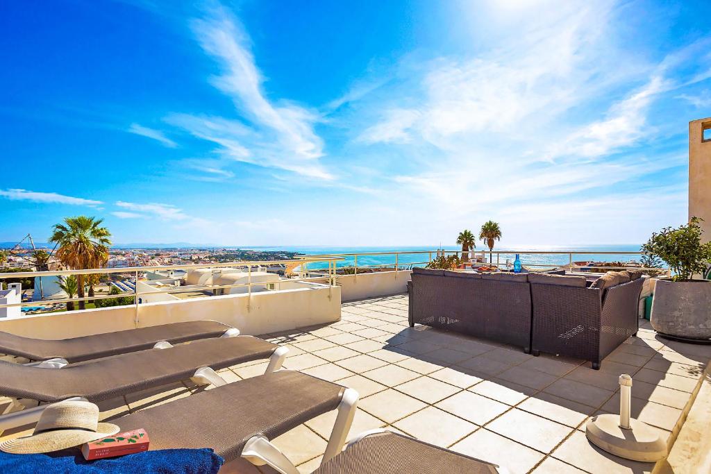 a balcony with chairs and a view of the ocean at WindMill Rooftop Panoramic OceanView Condo By BeCherish in Albufeira
