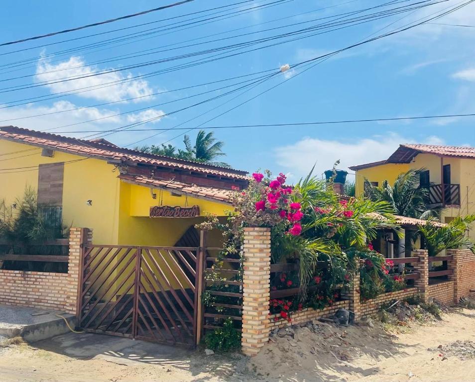 a house with a gate and flowers on it at Sertão beach in Tutóia