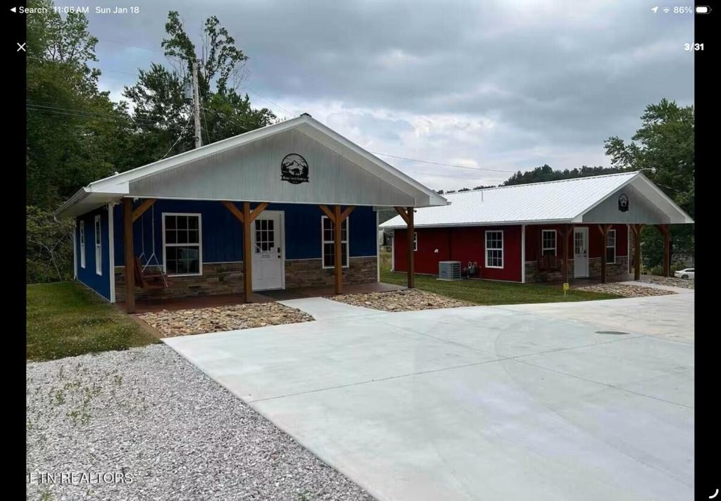 a small blue and red building with a garage at Blue Cozy Cottage in Oneida