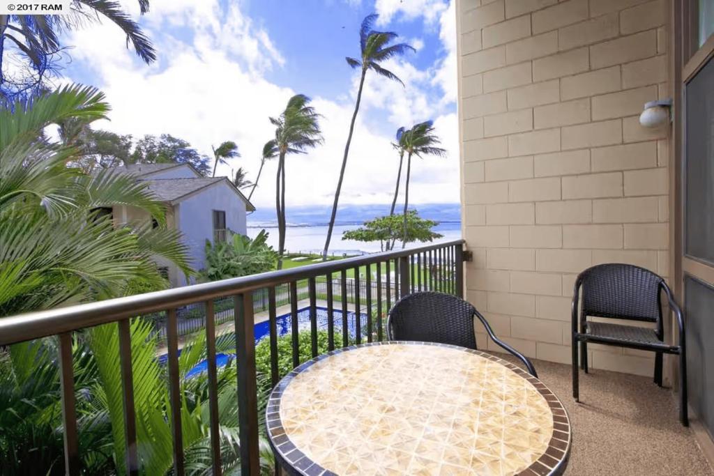 a balcony with a table and chairs and the ocean at Stunning 2BD 2BA Ocean Front Condo Great View, AC in Wailuku