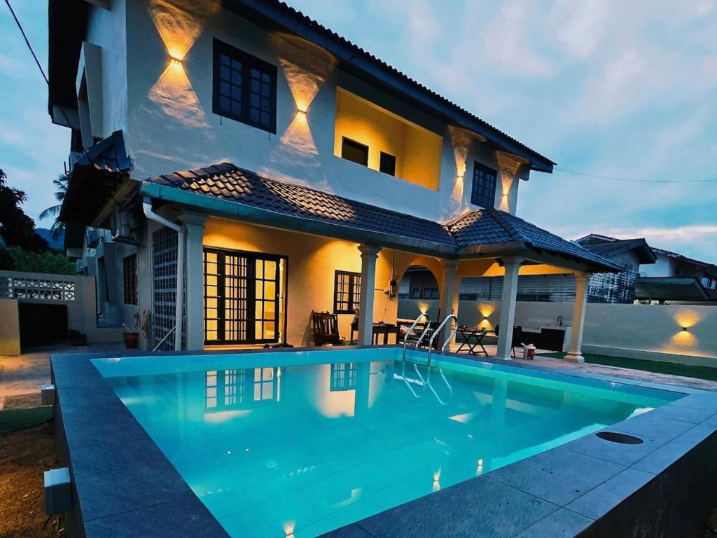 a villa with a swimming pool in front of a house at A6886 Swimming Pool Villa in Kuantan