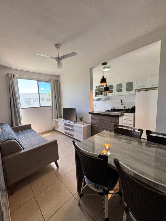 a kitchen and living room with a table and a couch at Apartamento prático e aconchegante - 5 min do Centro in Catanduva