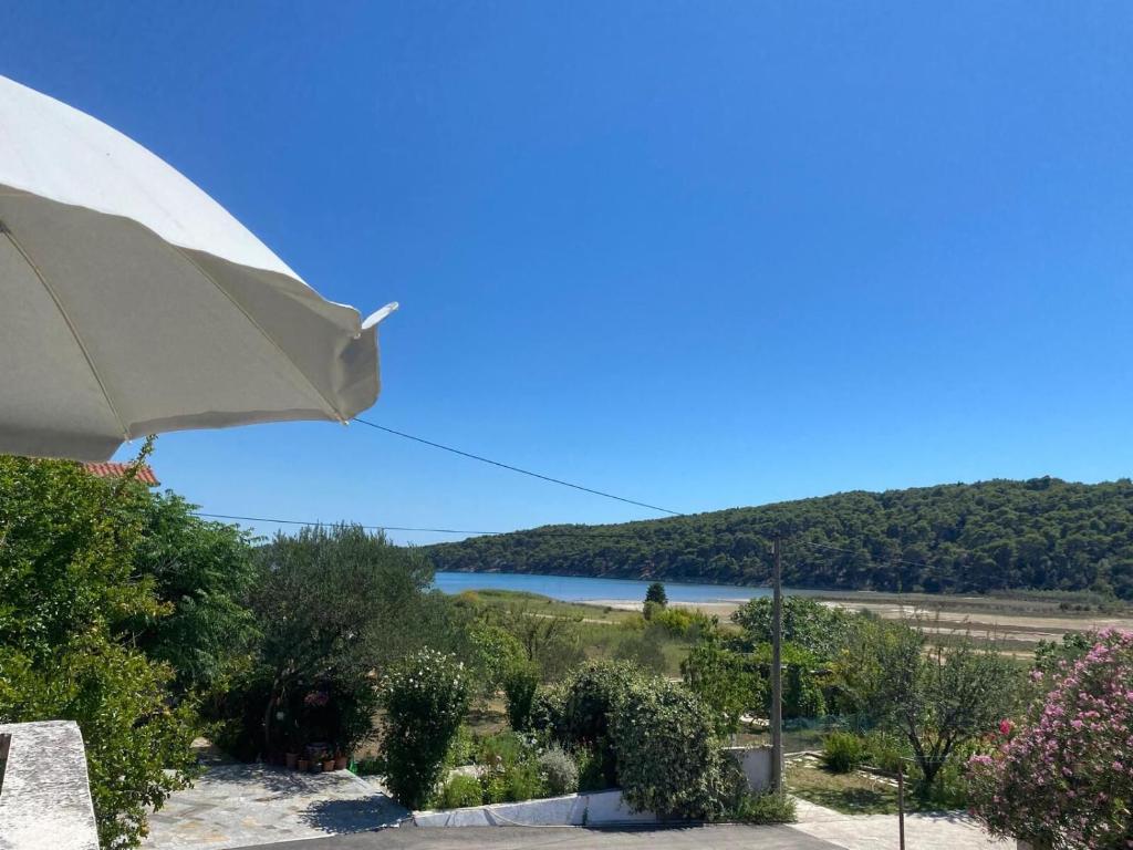 a view of a lake from a house with an umbrella at Apartment Solara in Kampor