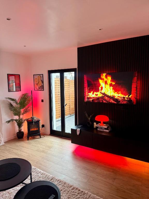 a living room with a fireplace with a fire in it at Appartement jacuzzi d'exception - proche Paris in Drancy