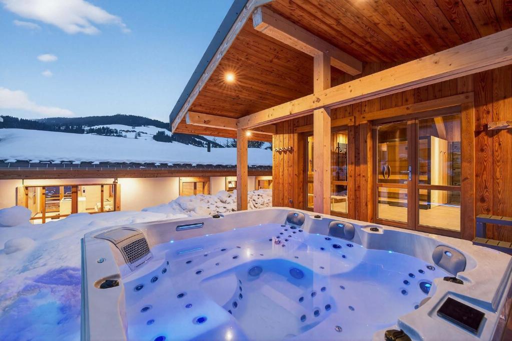 a hot tub in the middle of a snow covered house at Luxury Chalet with Private Spa & Wellness Area in Megève