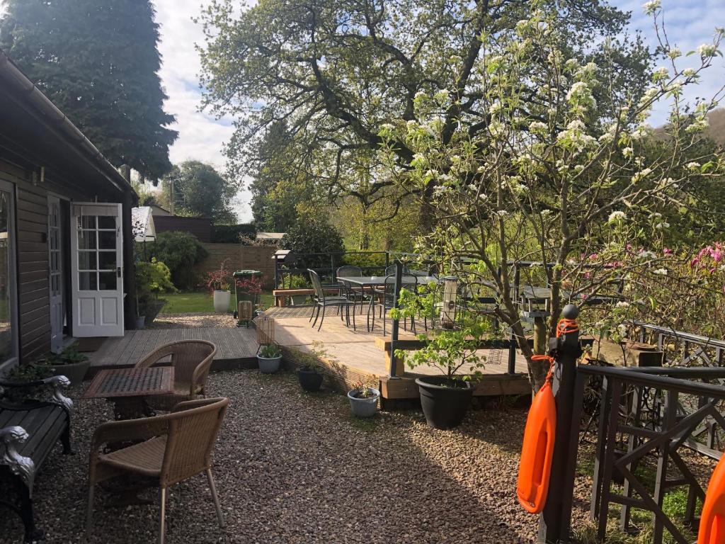 a garden with chairs and a table and a tree at Roundstone View in Bewdley