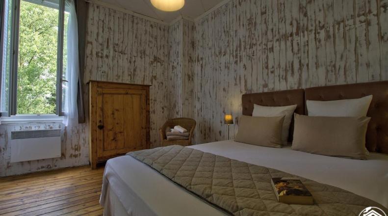 a bedroom with a large bed in a room at B&B Côté Moulin in Jayat