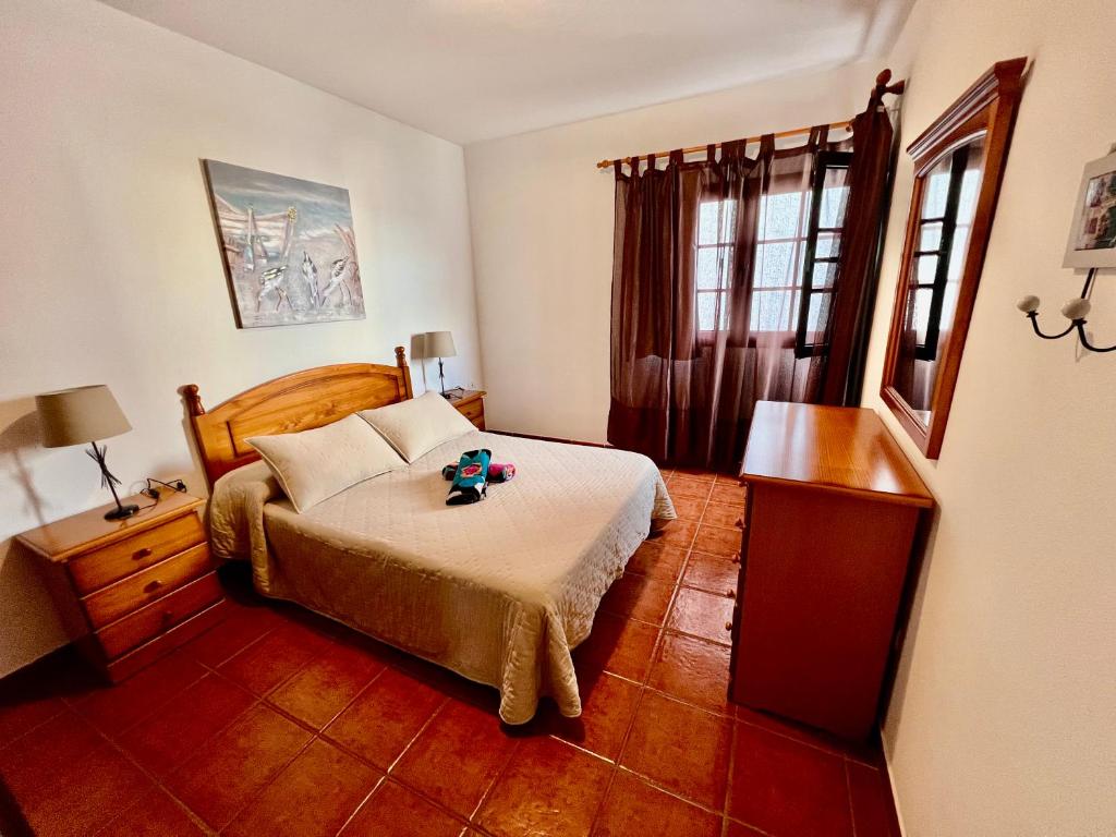 a bedroom with a bed and a dresser and window at Lupita's House in Punta Mujeres