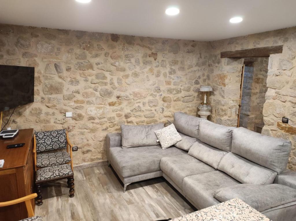 a living room with a couch and a tv at Casa Rural La Atalaya in Montarrón