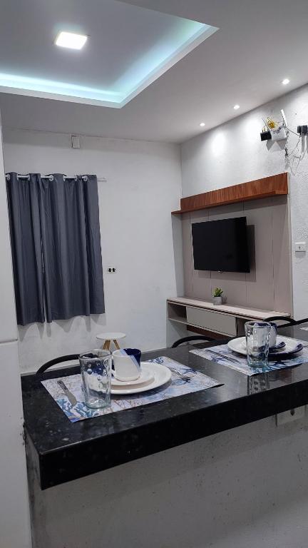 a kitchen with a table with plates and glasses on it at Águas de Maragogi residence in Maragogi