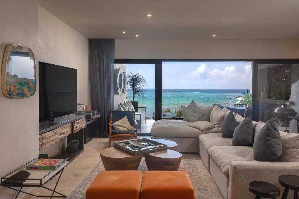a living room with a view of the ocean at Luxury 3BR Apartmen Tankah Beach plus Rooftop in Tulum