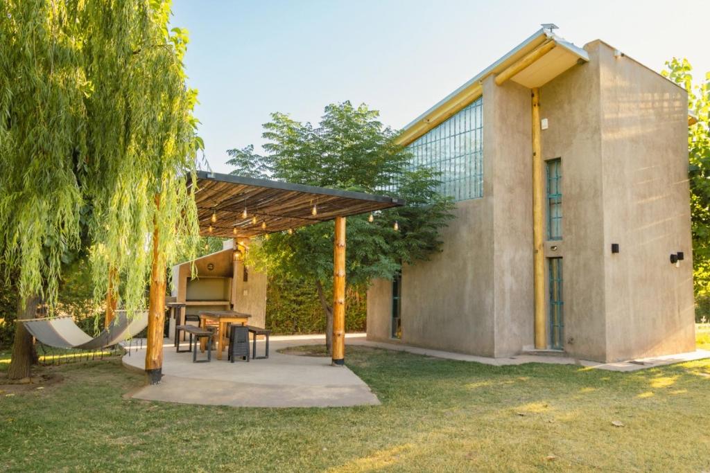 a brick house with a wooden pergola at Alamos de Perdriel in Perdriel
