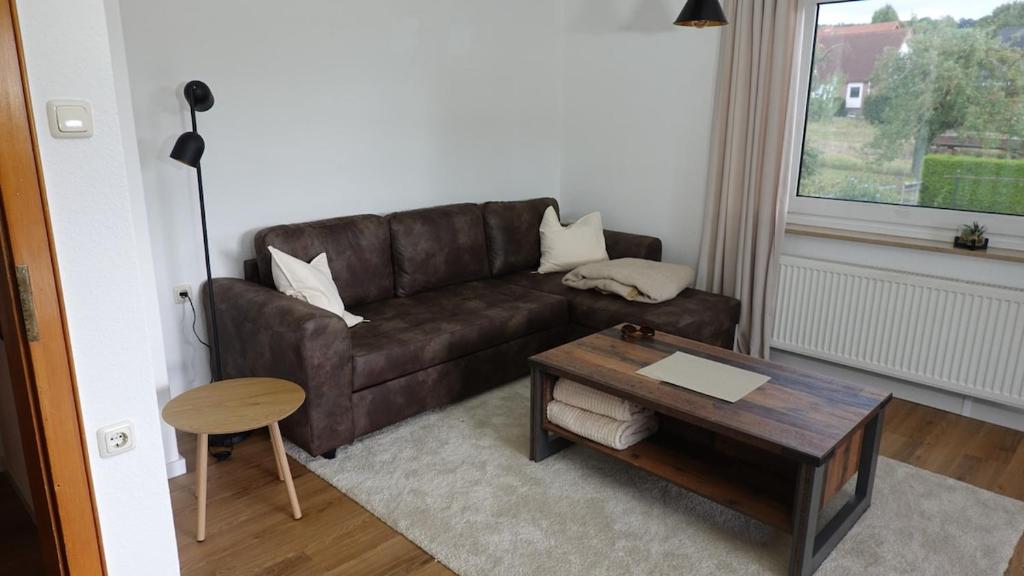 a living room with a brown couch and a table at FeWo Kalletal in Kalletal