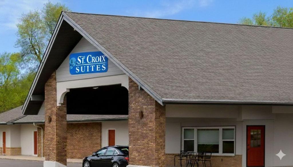 a gas station with a car parked outside of it at St Croix Suites - St Croix Falls in Saint Croix Falls