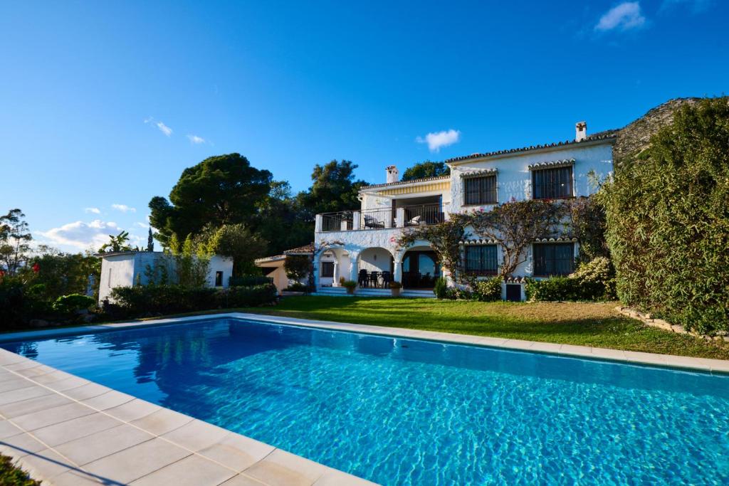an estate with a swimming pool in front of a house at Villa El Capricho in Mijas
