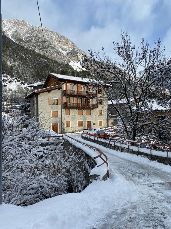 a building in the snow next to a road at BORMIO Alpine Suite in Valdidentro