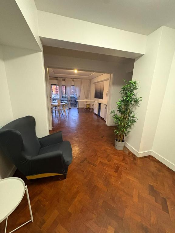 a living room with a black couch and a wooden floor at Hotel Campo Pequeno in Lisbon