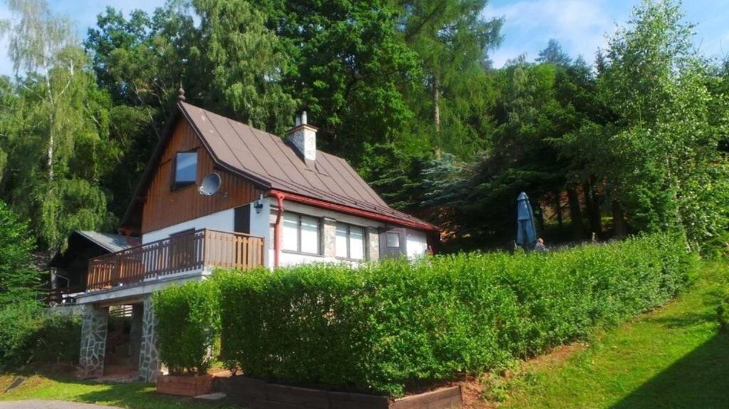 a large house with a balcony and a hedge at Chalupa Dolce Vita in Trutnov
