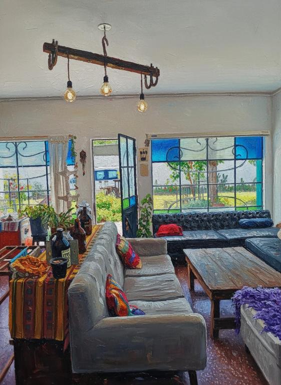 a living room with couches and a table and windows at Ramallo es Bienestar 8 plazas in Ramallo