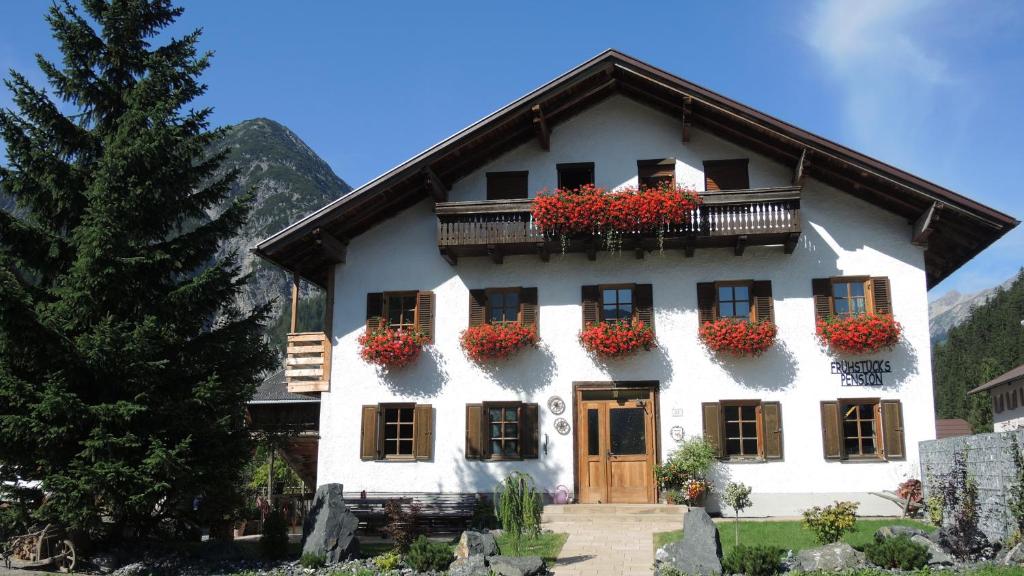 ein weißes Haus mit Blumenkästen drauf in der Unterkunft Trudis Hoamat in Bach