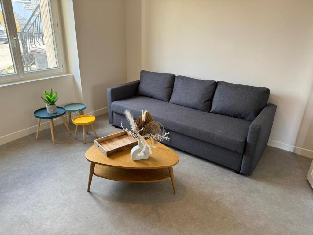 a living room with a blue couch and a table at Logis Le Pagnon in Brive-la-Gaillarde