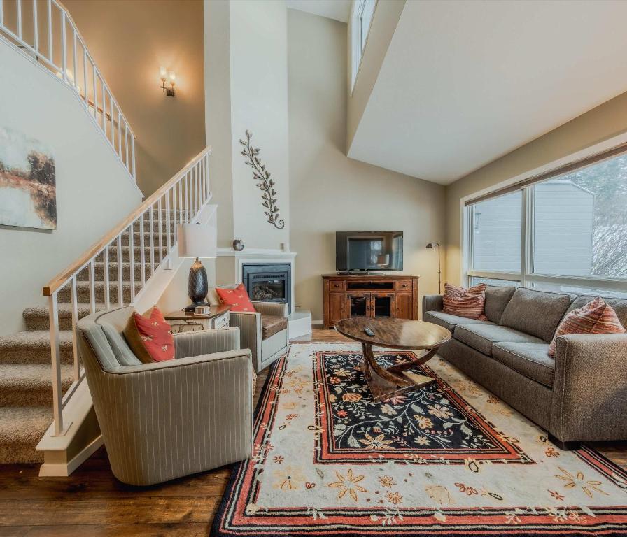 a living room with two couches and a staircase at Meadow Lake Townhouse For 6ppl in Columbia Falls