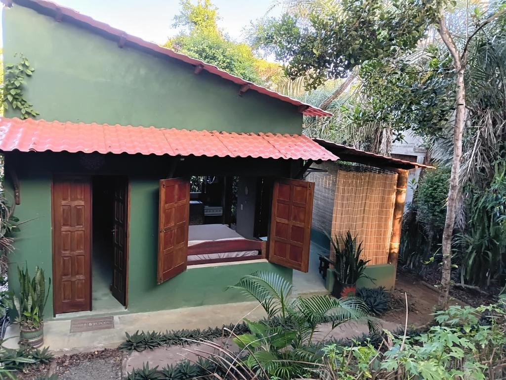 a small green house with a red roof at Recanto BantuArte-Boipeba in Cairu
