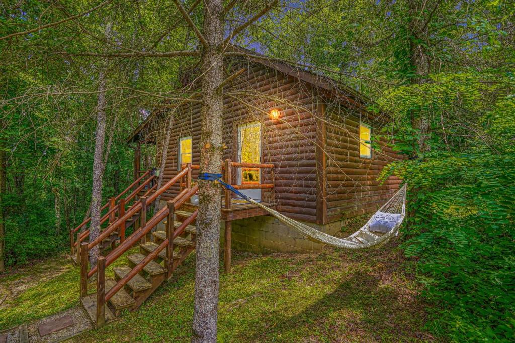 a log cabin with a hammock in the woods at Havenwood in Logan