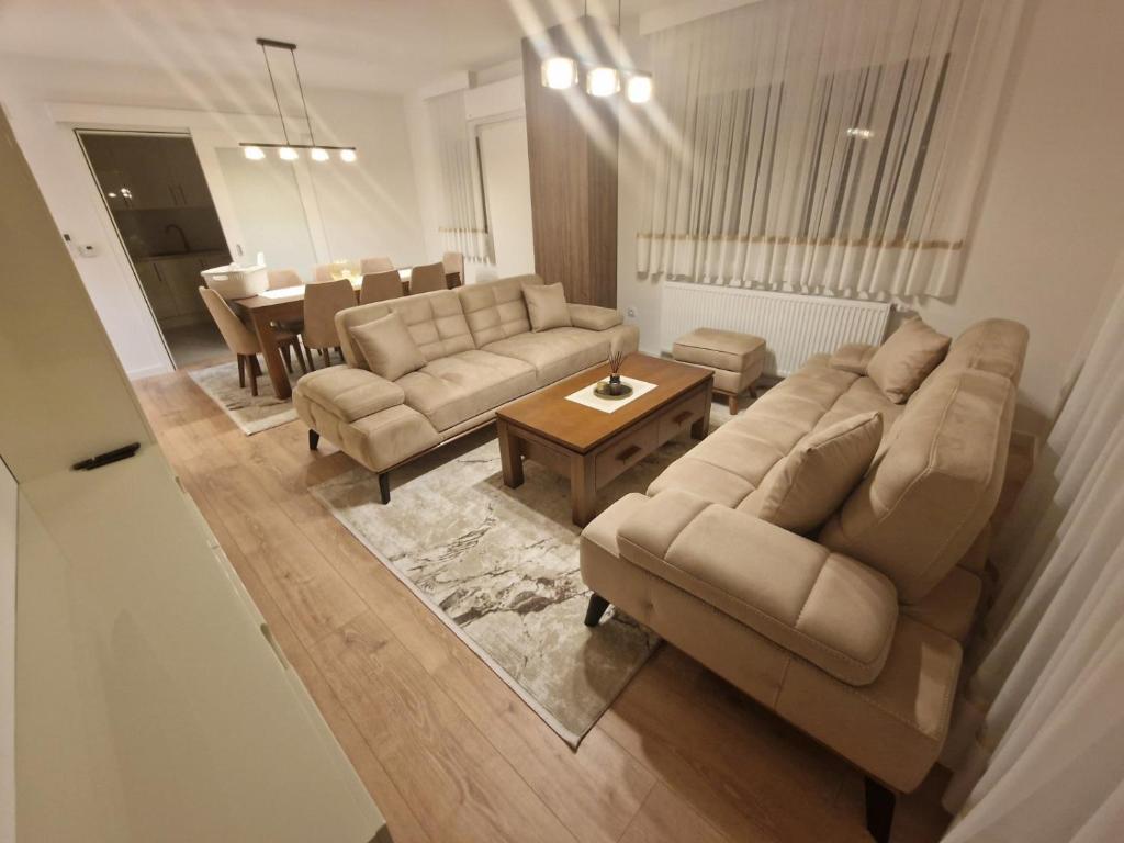 a living room with two couches and a table at Apartman Djurić in Brčko
