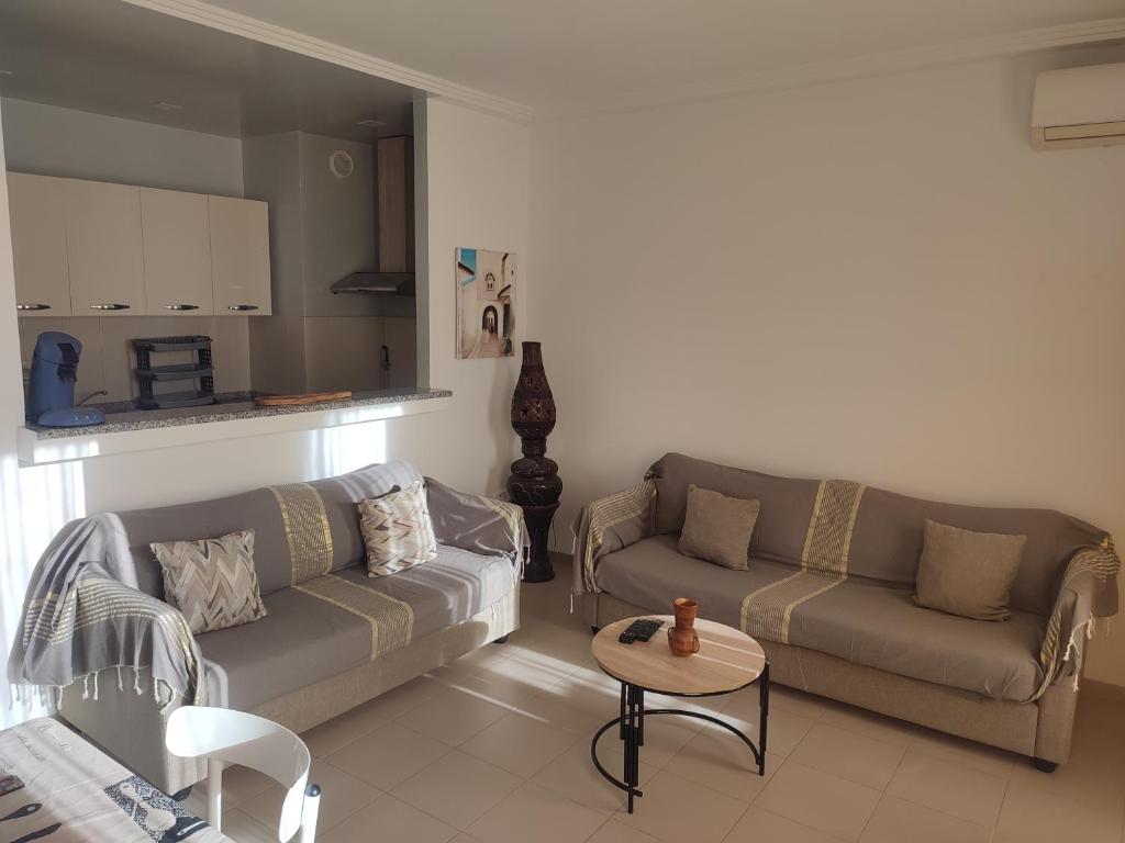 a living room with two couches and a table at L'Ambre in Hammamet