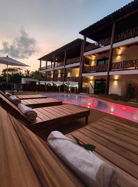 a resort with a swimming pool and a building at Hotel Alfa Troncones Mexico in Troncones