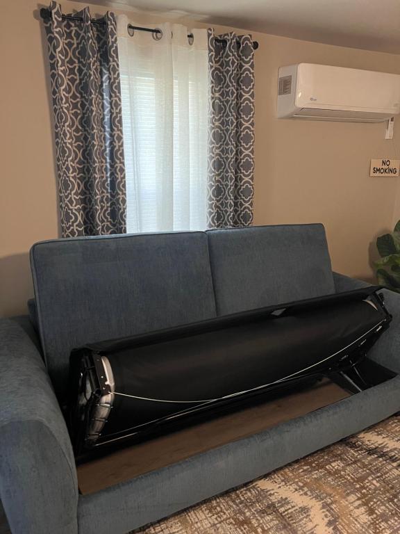 a couch sitting in a living room next to a window at Skipper Apt #4 in Rockingham