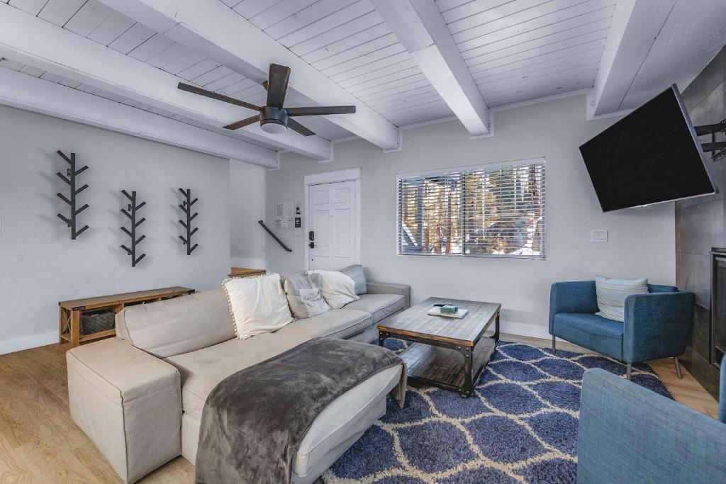a living room with a couch and a flat screen tv at Zephyr Chalet Steps from Zephyr Cove in Glenbrook