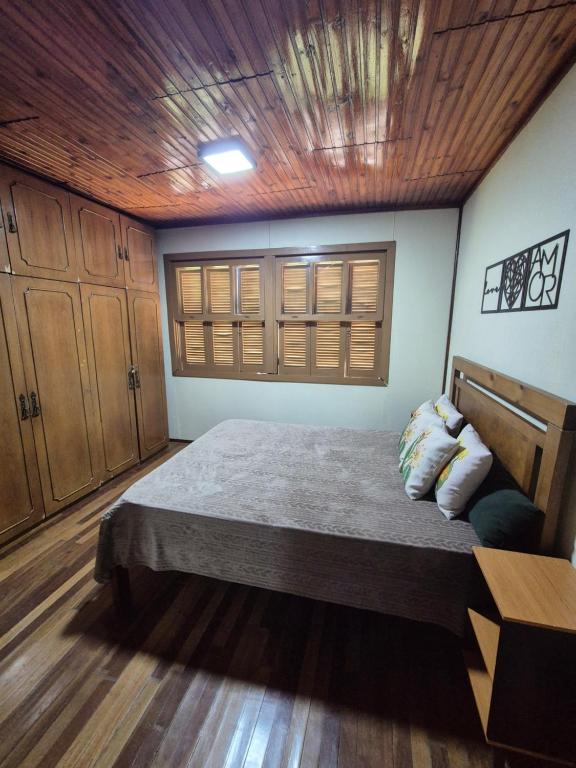 a bedroom with a bed with a wooden ceiling at Casa completa in Caçapava do Sul