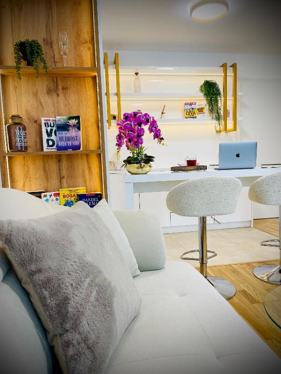 a living room with a couch and a table with flowers at SOL LUX Tuzla in Tuzla
