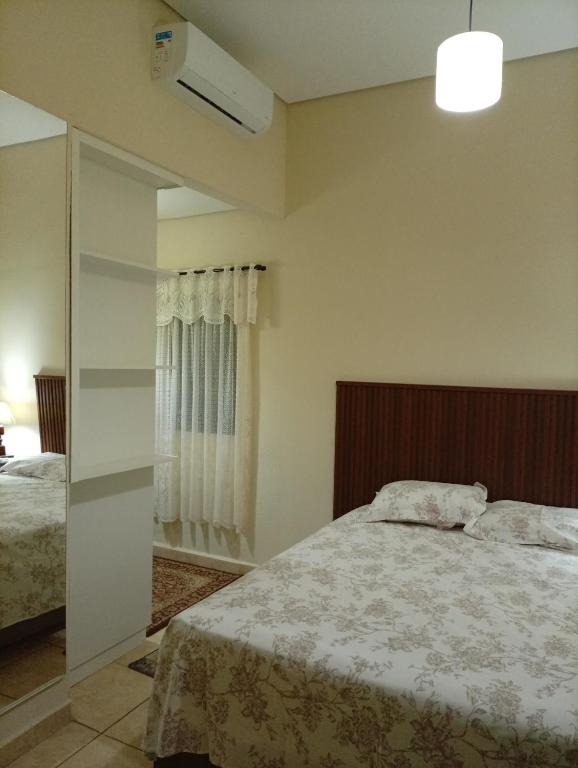 a bedroom with a large bed and a window at Quarto Suite & Cozinha in Piraju