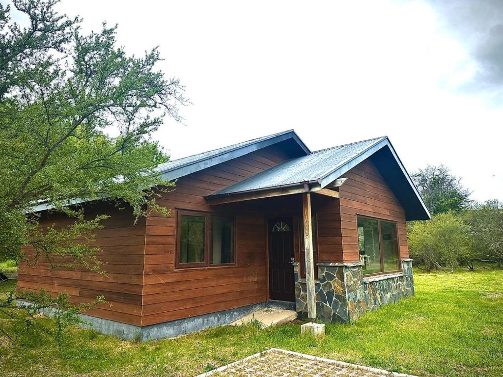 a small wooden house with a gambrel roof at Cabañas Raíces de la Patagonia in Coihaique
