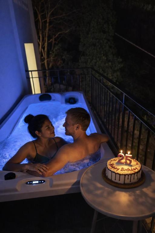 a man and a woman in a hot tub with a cake at Il Sogno in Como