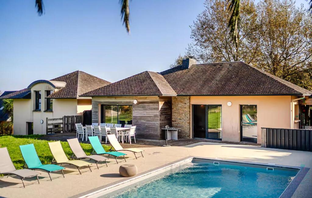 a home with a swimming pool and chairs and a house at Lovely Home In Lanvéoc in Lanvéoc
