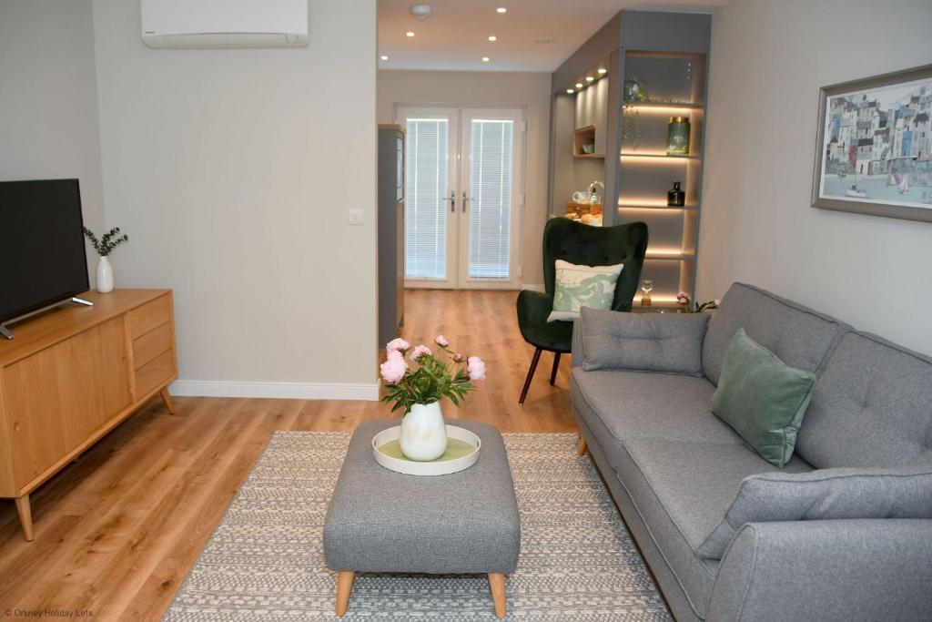 a living room with a couch and a tv at 6 Zetland Road, Kirkwall, Orkney - OR00275F in Kirkwall
