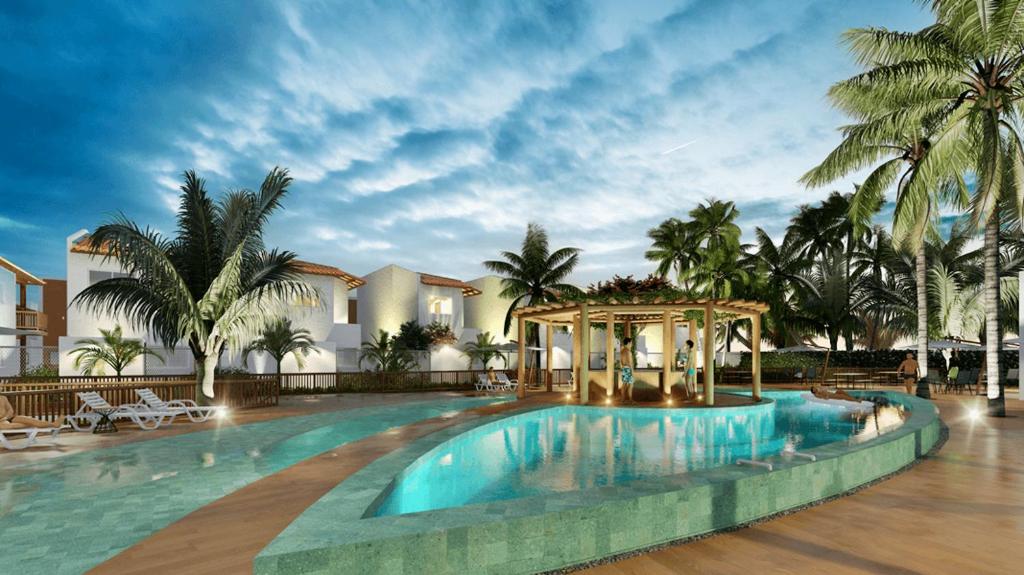 a large swimming pool with a gazebo and palm trees at Maramar Beach House in Luis Correia
