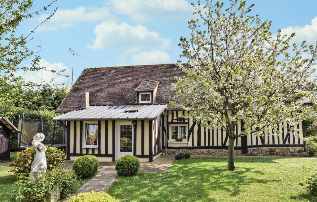 an exterior view of a house with a tree at Maison Avec Piscine Couverte in Fervaques