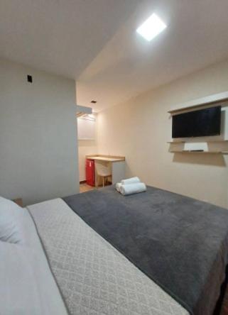 a bedroom with a large bed and a desk at Riviera Sanary 1207 Nova Almeida in Serra