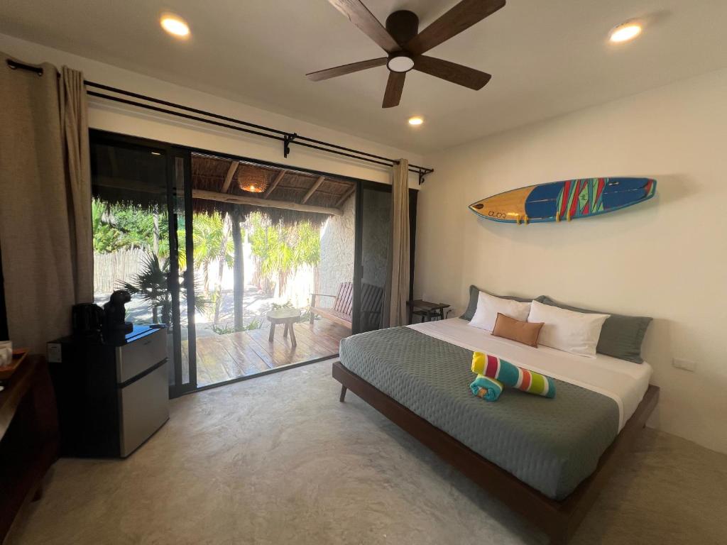 a bedroom with a bed with a surfboard on the wall at Nomads Kite House in El Cuyo