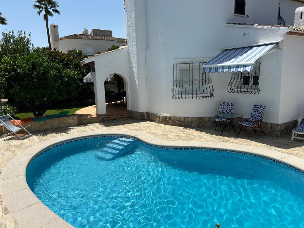 a swimming pool in front of a house at La Duna de Denia in Denia